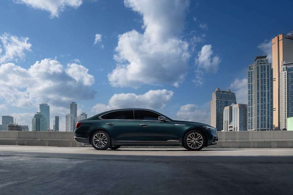 Elegant sedan parked on a rooftop with a city skyline backdrop under bright blue skies.